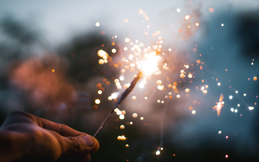 Close up pic of a hand holding a lit sparkler