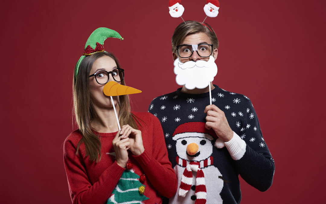 Pic showing two people wearing silly Christmas jumpers and masks